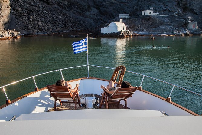 Santorini: Motor Yacht Sunset Cruise with 5-Course Dinner - The southern coast: red beaches, white cliffs, and Akrotiri Lighthouse